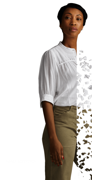 A woman standing and staring straight ahead. Actor portrayal.